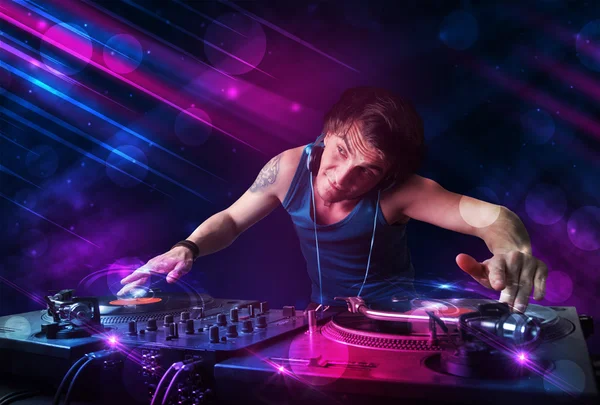 Junger DJ spielt auf Plattentellern mit Farb-Lichteffekten — Stockfoto