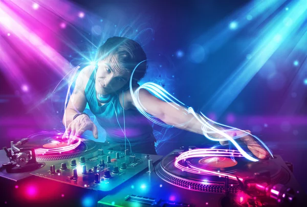 Energiska dj blandande musik med kraftfulla ljuseffekter — Stockfoto