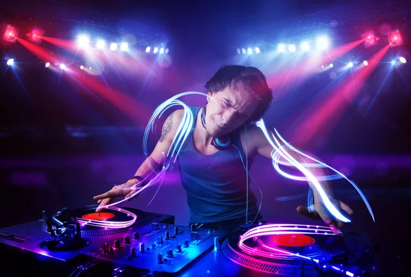 Disc jockey playing music with light beam effects on stage — Stock Photo, Image