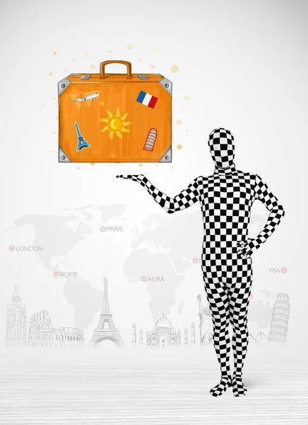man in full body suit presenting vacation suitcase