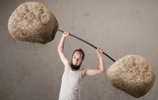 Mager guy tillen grote steen gewichten — Stockfoto