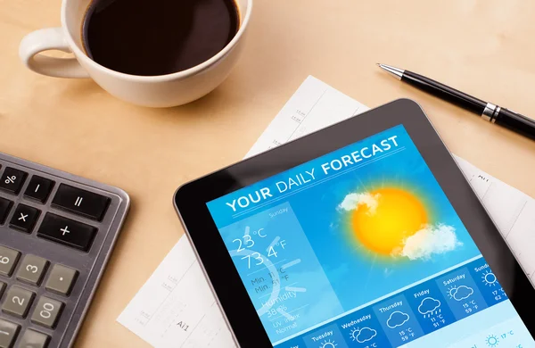 Tablet PC que muestra el pronóstico del tiempo en pantalla con una taza de café —  Fotos de Stock