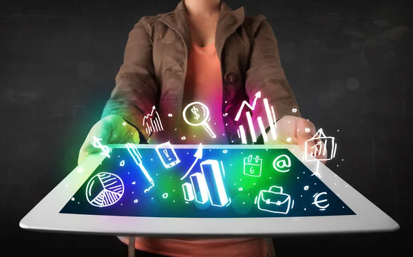 Young person holding tablet with graph and chart symbols — Stock Photo, Image