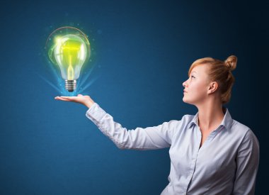 bir iş kadını elinde parlayan ampul