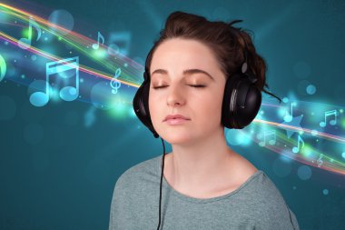 Kulaklıkla müzik dinleyen genç bir kadın.