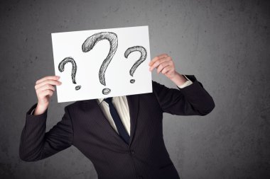 onun önünde soru işareti olan bir kağıt tutan işadamı