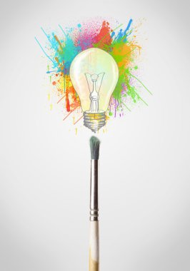 renkli boya sıçraması ve ampul ile fırça yakın çekim