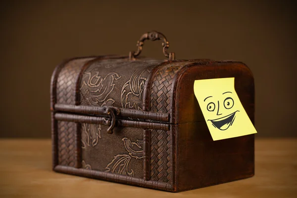 Post-it notera med smiley ansikte klistras på ett smyckeskrin — Stockfoto