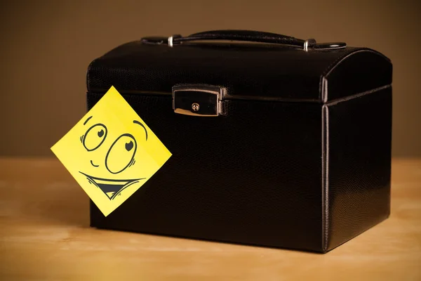 Post-it note with smiley face sticked on a jewelry box — Stock Photo, Image