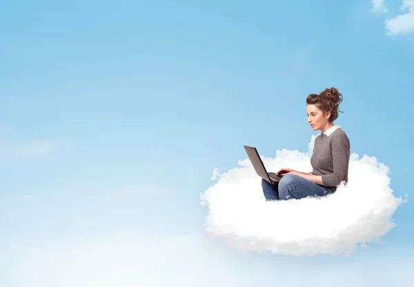 Young woman with laptop sitting on cloud with copy space — Stock Photo, Image