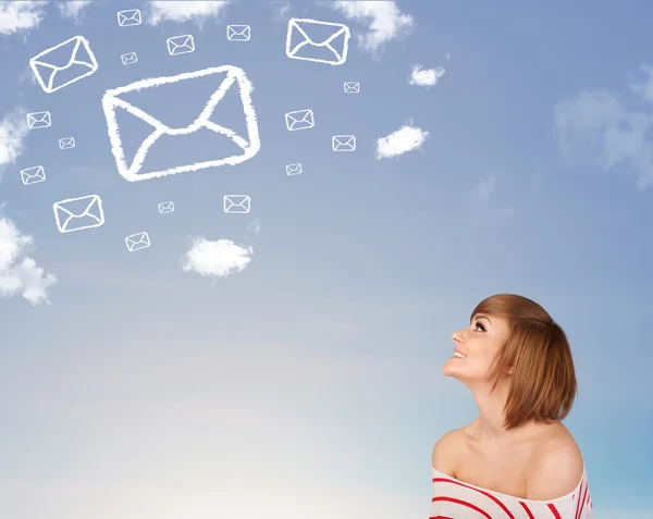 Young girl looking at mail symbol clouds on blue sky — Stock Photo, Image