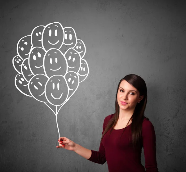 Woman holding a bunch of smiling balloons — Stock Photo, Image