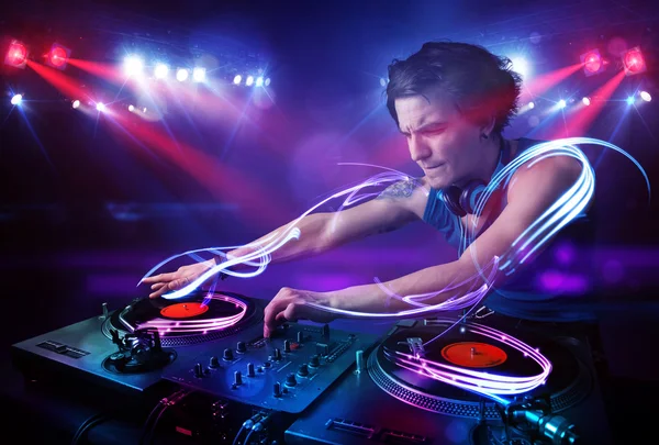 Discjockey som spelar musik med ljusstrålen effekter på scenen — Stockfoto