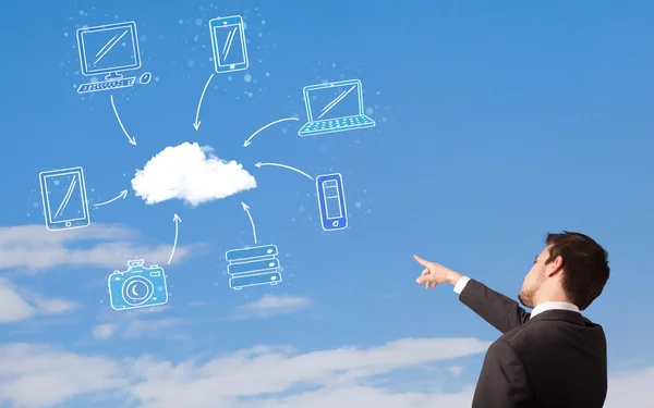 Pohledný muž při pohledu na cloud výpočetní koncept na modré obloze — Stock fotografie