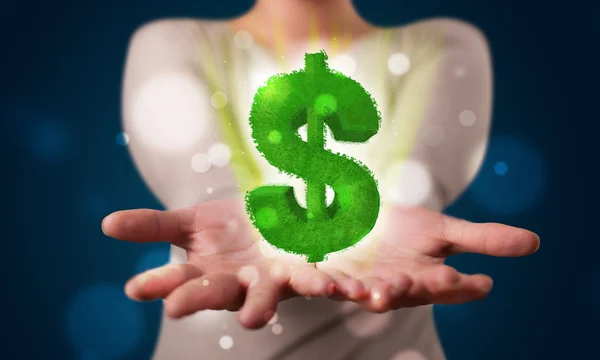 Молодая женщина представляет зеленый светящийся знак доллара — стоковое фото