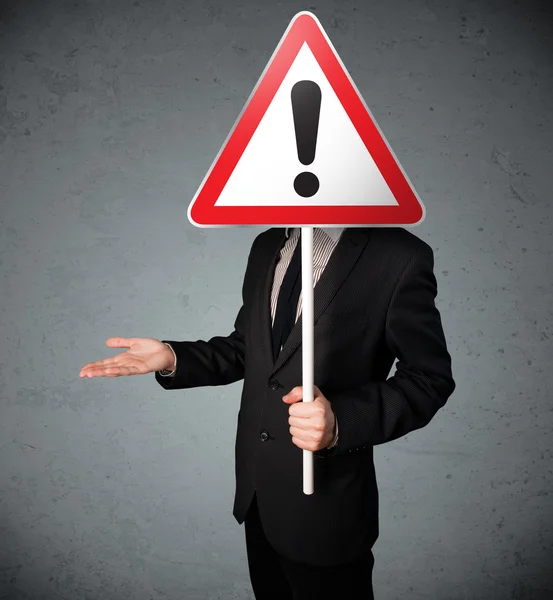 Businessman holding an exclamation road sign — Stock Photo, Image