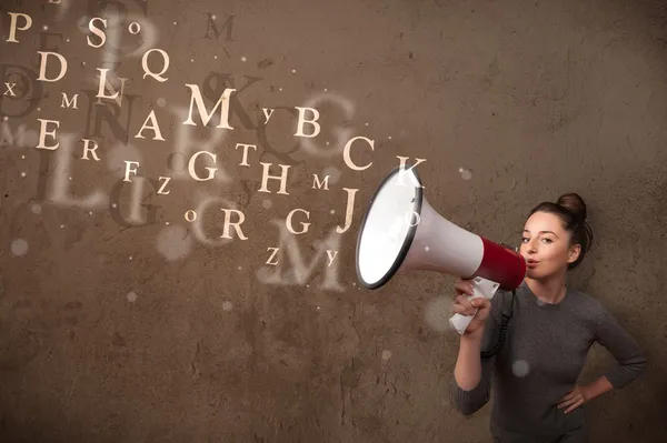 Ung flicka skriker in i megafon och text kommer ut — Stockfoto