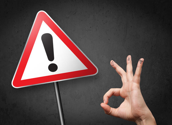 Счастливые улыбающиеся пальцы глядя на треугольник предупреждающий знак с excla
