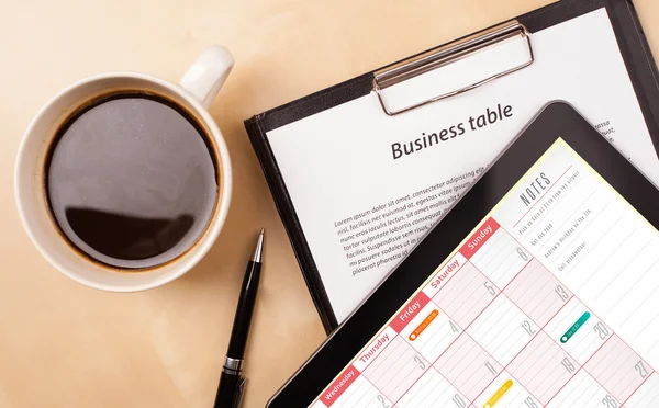 Tablet pc showing calendar on screen with a cup of coffee on a d — Stock Photo, Image