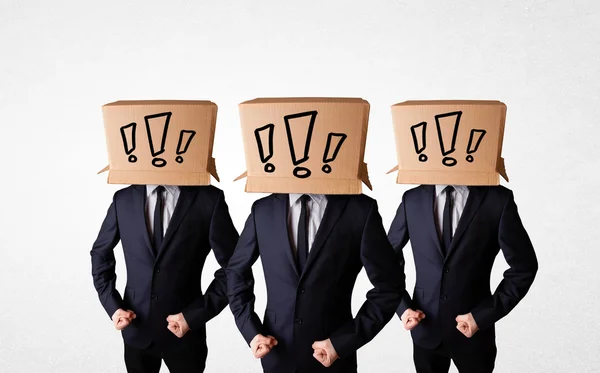 Men gesturing with exclamation marks on box on their head — Stock Photo, Image