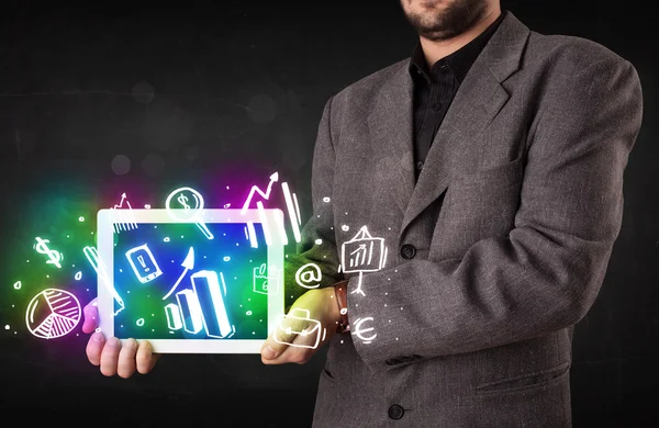 Young person holding tablet with graph and chart symbols — Stock Photo, Image