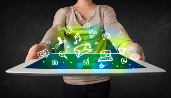 Person holding a tablet with media icons and symbols — Stock Photo, Image