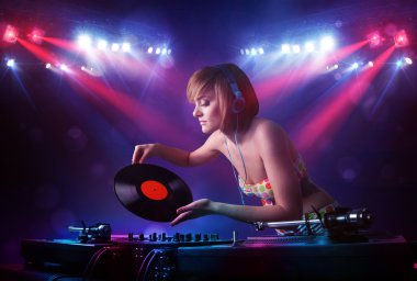 Genç dj kayıtları bir kalabalığın önünde sahnede karıştırma