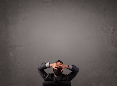 kopya alanı bir duvarın önünde oturan işadamı