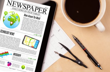 Tablet bilgisayarı haberleri ekranda bir fincan kahveyle sunar.