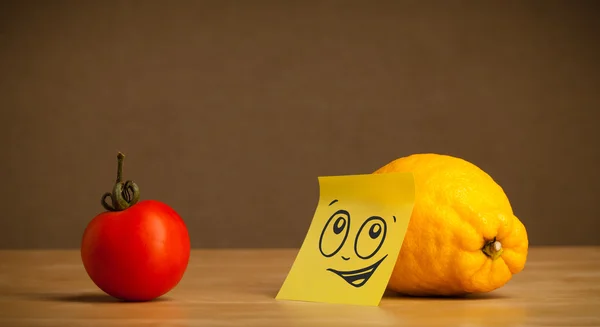 Lemon with post-it note looking at tomato — Stock Photo, Image