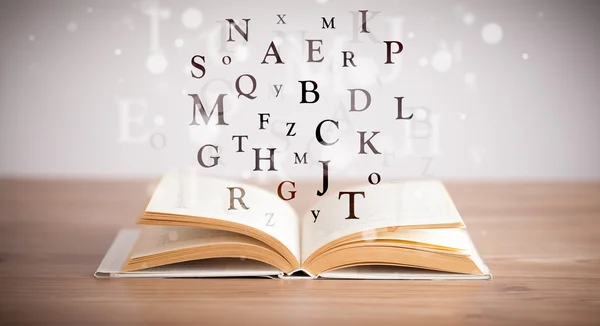 Opened book with flying letters — Stock Photo, Image