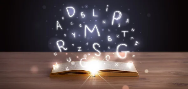 Libro abierto con letras brillantes volando — Foto de Stock