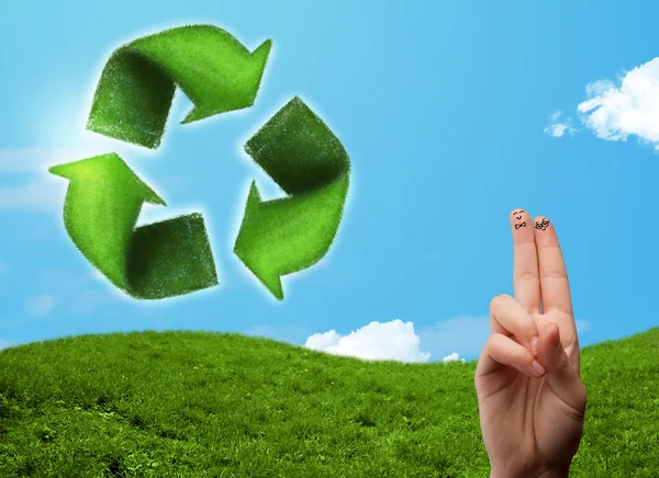 Щасливі усміхнені пальці, дивлячись на знак переробки зеленого листя — стокове фото