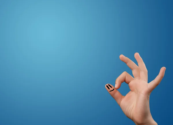 Happy smiley face fingers looking at empty blue background copy — Stock Photo, Image