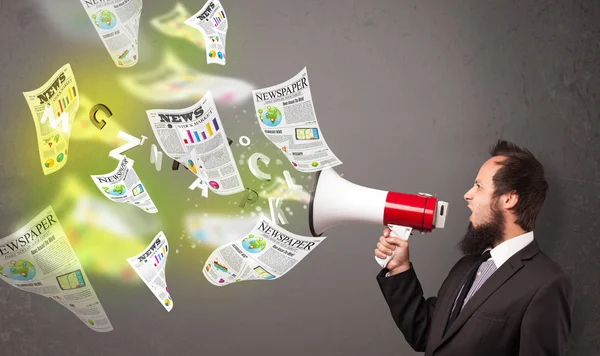 Guy yelling into loudspeaker and newspapers fly out — Stock Photo, Image