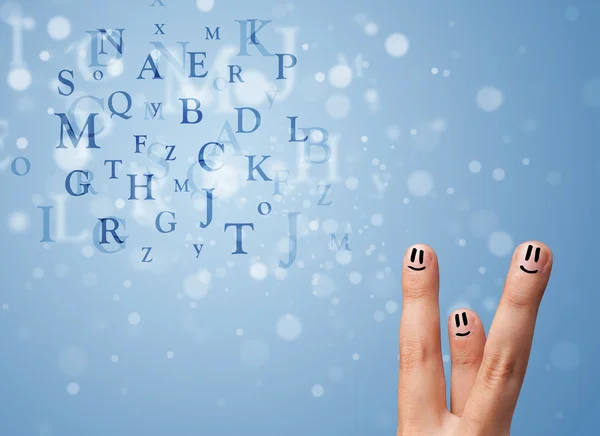 Happy smiley fingers looking at mixture of bokeh letters — Stock Photo, Image