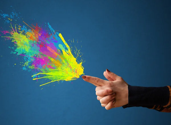 Salpicaduras de colores están saliendo de las manos en forma de pistola —  Fotos de Stock