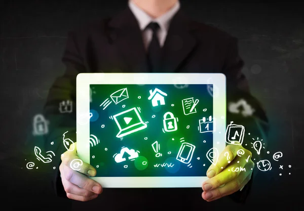 Pessoa segurando tablet com ícones e símbolos de mídia verde — Fotografia de Stock