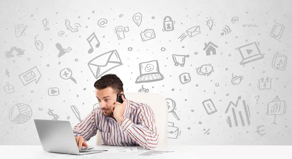 Business man sitting at table with hand drawn media icons — Stock Photo, Image