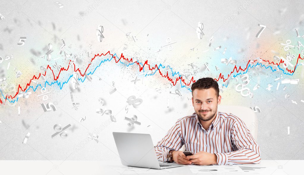 Business man sitting at table with stock market graph
