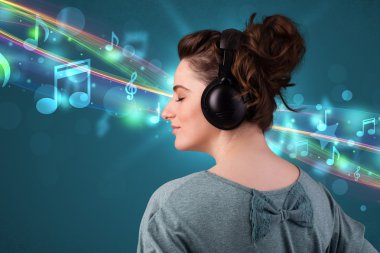 Kulaklıkla müzik dinleyen genç bir kadın.