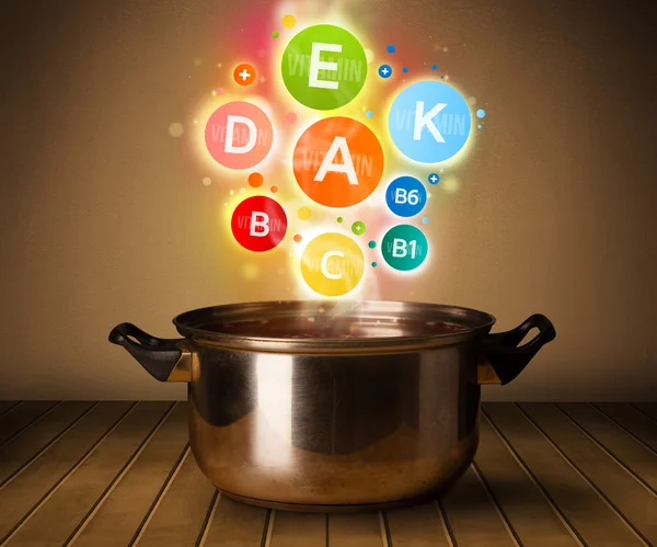 Colorful vitamins coming out from cooking pot — Stock Photo, Image