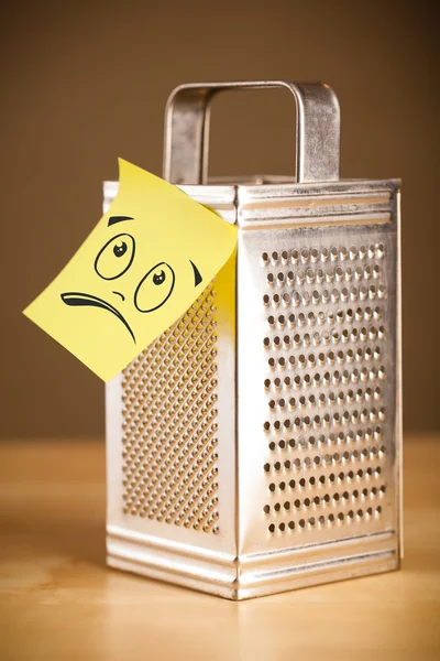 Post-it note with smiley face sticked on grater — Stock Photo, Image
