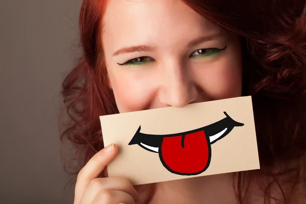 Feliz bonita mujer sosteniendo tarjeta con divertido smiley — Foto de Stock