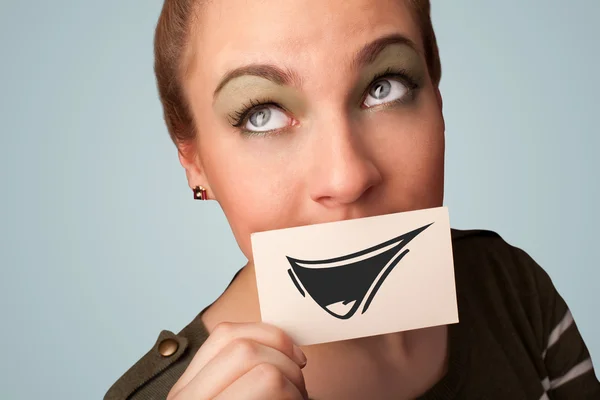 Glückliches nettes Mädchen hält Papier mit lustigen Smiley-Zeichnung — Stockfoto