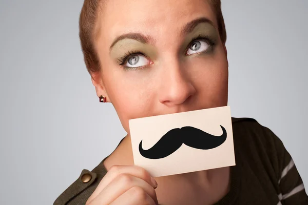 Happy cute girl holding paper with mustache drawing — Stock Photo, Image