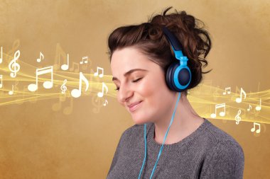 Kulaklıklı genç bir kadın müzik dinliyor.