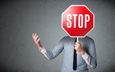 İşadamı elinde dur levhası tutuyor.
