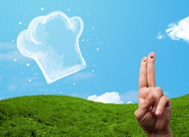 Mutlu gülen yüzlü parmaklar aşçı şapkasının resmine bakıyor.