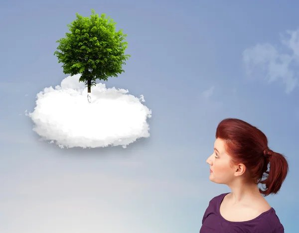 Mladá dívka na zelený strom na vrcholu bílý oblak — Stock fotografie